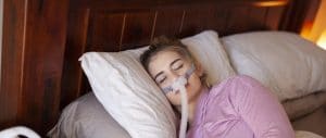 woman sleeping soundly on her side with cpap mask for sleep apnea therapy