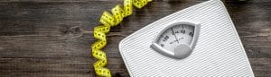 Lose weight concept. Bathroom scale, measuring tape, apples on wooden background top view.